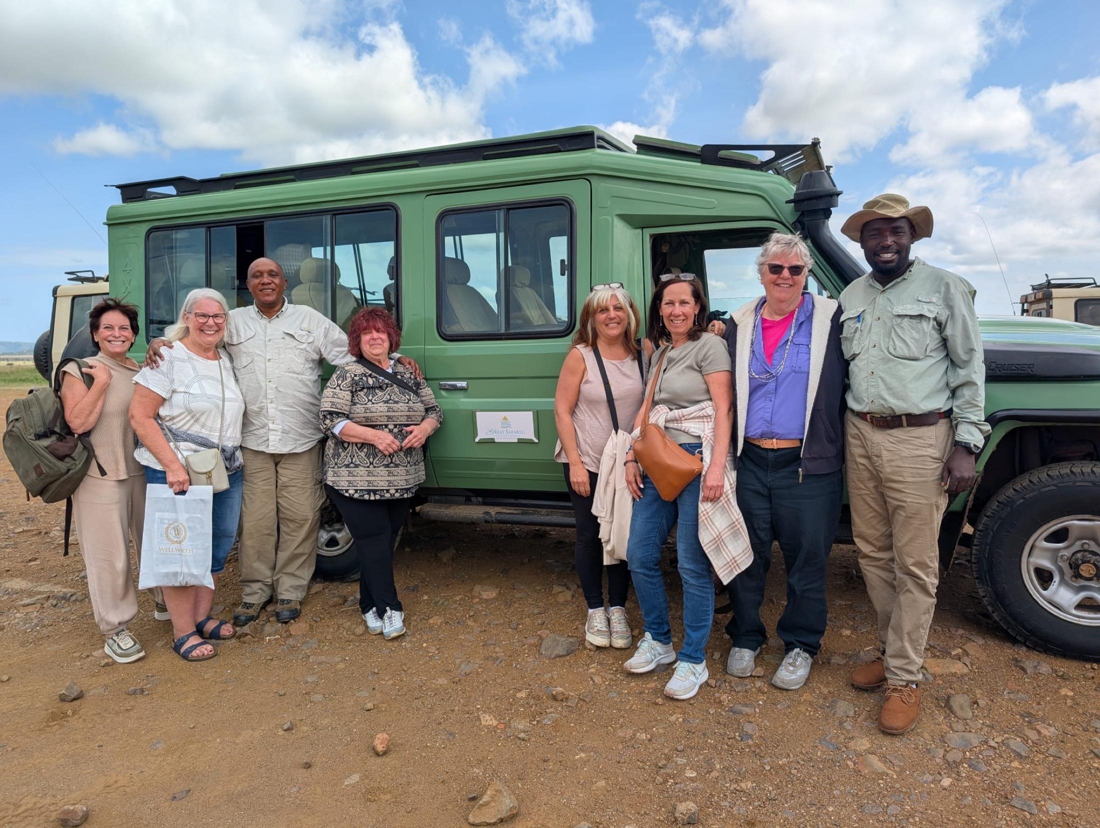 Soul-O women travelers with safari guides beside a game drive vehicle